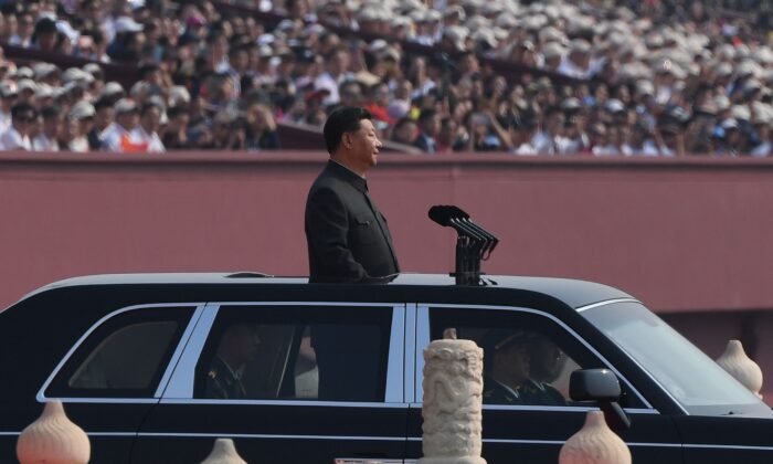 Le chef du régime chinois Xi Jinping commence un examen ses troupes lors d'un défilé militaire sur la place Tiananmen à Pékin le 1er octobre 2019. (GREG BAKER/AFP/Getty Images)