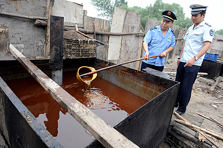 La police inspecte l'huile de cuisson illégale saisie lors d'une opération mesures répressives à Pékin le 2 août 2010. (STR/AFP/Getty Images)
