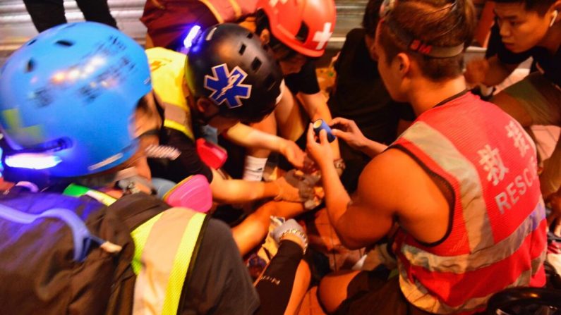 Des médecins entourent le manifestant blessé dans le quartier de Yuen Long, à Hong Kong, le 4 octobre. (Yu Tianyou / The Epoch Times)