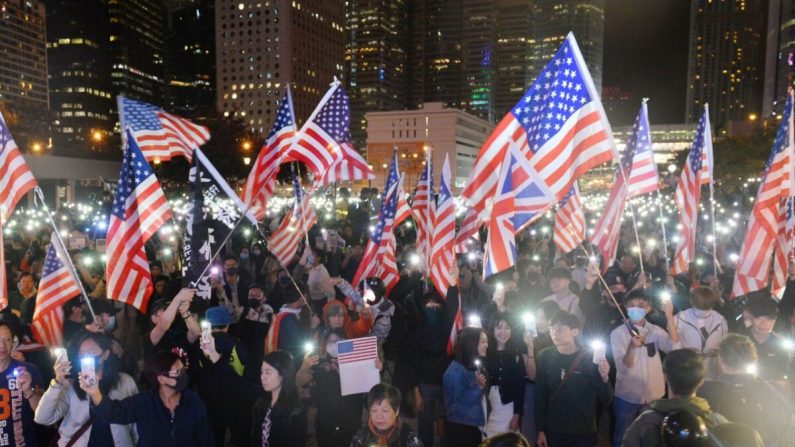 Des manifestants brandissent des drapeaux américains et brandissent leur téléphone portable allumé alors qu'ils assistent à un rassemblement sur la place d'Édimbourg à Hong Kong, le 28 novembre 2019. (Sung Pi Lung/The Epoch Times)