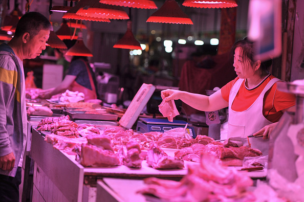 -Un client achète de la viande sur un marché de Shenyang, dans la province du Liaoning (nord-est de la Chine), le 12 juin 2019. - En Chine, l'inflation a atteint son plus haut niveau en plus d'un an sous l'effet de la flambée des prix du porc et des fruits Épidémie de peste porcine africaine et intempéries, d'après les données officielles publiées le 12 juin. Photo STR / AFP via Getty Images.
