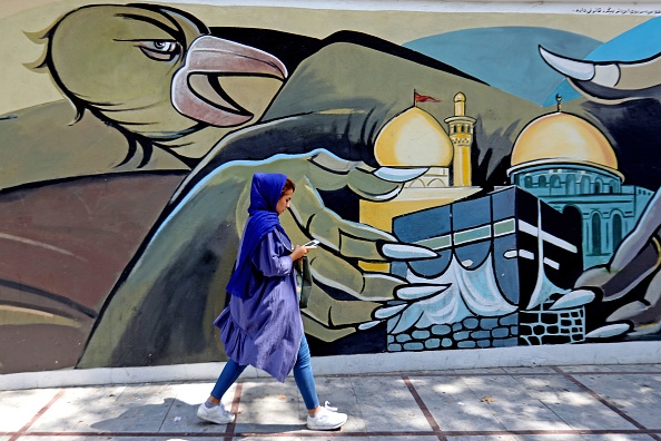 -Une femme passe devant une murale politique sur la Place de la Palestine dans la capitale iranienne, Téhéran, le 7 septembre 2019. L'Iran a annoncé samedi qu'il avait lancé des centrifugeuses avancées pour augmenter ses stocks d'uranium enrichi. Photo ATTA KENARE / AFP via Getty Images.