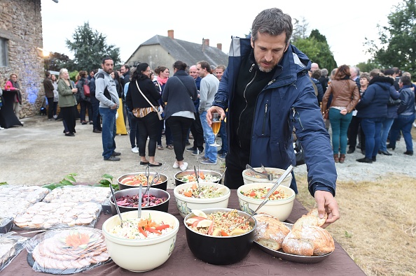 -L'acteur français Guillaume Canet prend un morceau de pain lors de la projection en avant-première de son film "Au nom de la Terre" dans une ferme à Saint-Pierre où le film a été tourné -sur-Orthe, dans l'ouest de la France, le 6 septembre 2019. Photo JEAN-FRANCOIS MONIER / AFP via Getty Images.