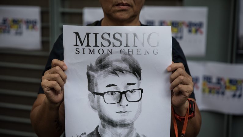 Une femme tient une affiche représentant le portrait de Simon Cheng, un employé du consulat britannique, devant le consulat britannique à Hong Kong le 21 août 2019. (Chris McGrath/Getty Images)