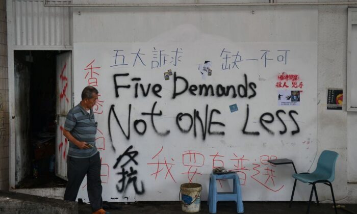 Un homme passe devant un mur couvert de graffitis à Hong Kong le 7 octobre 2019. (Nicolas Asfouri/AFP via Getty Images)