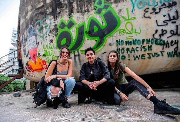 -Des Libanaises assises devant un graffiti en train de lire une "révolution" arabe dessinée sur le mur du bâtiment en forme de dôme situé au centre de la capitale, Beyrouth. Une manifestation en cours contre les augmentations d'impôts et la corruption officielle. Photo par ANWAR AMRO / AFP via Getty Images.