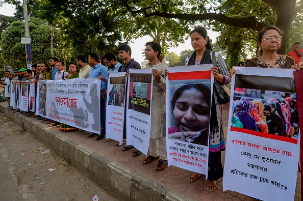 -Les activistes sociaux forment une chaîne humaine pour protester et sensibiliser les travailleurs migrants bangladais pouvant faire face à diverses formes de maltraitance, y compris des violences physiques, psychologiques et même sexuelles commises par des employeurs en Arabie saoudite, à Dhaka le 1er novembre 2019. Au total, 2 165 travailleuses sont revenues au Bangladesh au cours des 21 derniers mois après avoir survécu dans des conditions inhumaines et 87 autres travailleuses migrantes ont été mises à mort. Photo de MUNIR UZ ZAMAN / AFP via Getty Images.