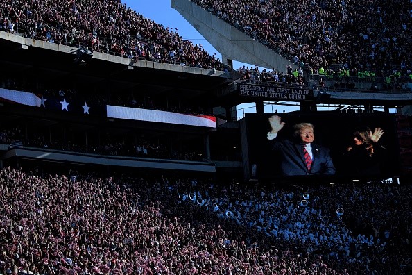 -Le président américain Donald Trump et la première dame américaine Melania Trump apparaissent sur un écran lors d'un match de football au stade Bryant-Denny Stadium le 9 novembre 2019 à Tuscaloosa, en Alabama. Photo de Brendan Smialowski / AFP via Getty Images.
