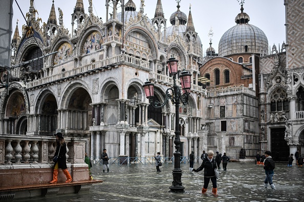-Les piétons traversent la place Saint-Marc inondée et dépassent la basilique Saint-Marc après une nuit exceptionnelle de marée haute "Alta Acqua", le 13 novembre 2019 à Venise. Photo de MARCO BERTORELLO / AFP via Getty Images.