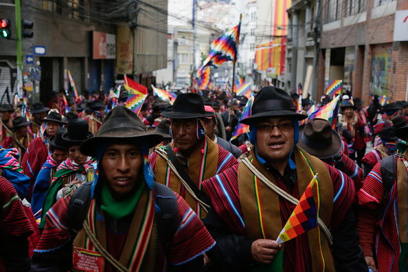 -Les partisans d'Evo Morales portant les ponchos traditionnels et tenant des drapeaux Wiphala prennent part à une manifestation à La Paz, en Bolivie. Depuis la démission d'Evo Morales ses partisans inondent les rues d'El Alto et se heurtent à la police. Photo de Gaston Brito Miserocch / Getty Images.
