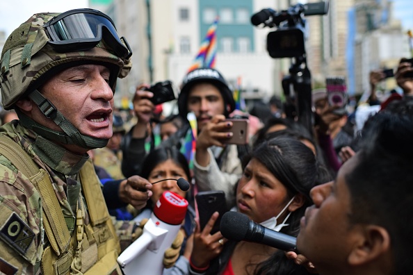 -Un soldat s'entretient avec des partisans de l'ex-président bolivien Evo Morales lors d'une manifestation contre le gouvernement de transition à La Paz le 15 novembre 2019. Photo de RONALDO SCHEMIDT / AFP via Getty Images.