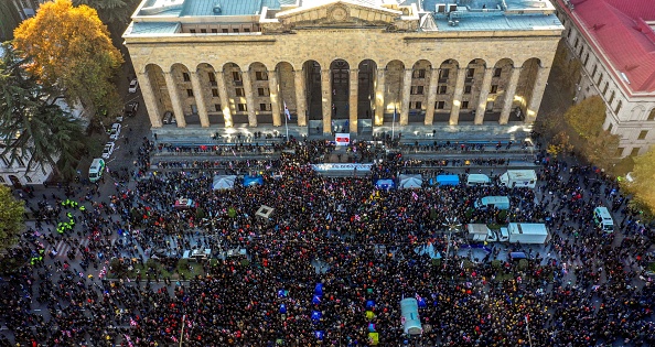 -Une vue aérienne d'une foule de partisans de l'opposition géorgienne rassemblés devant le parlement de la Géorgie, dans le centre de Tbilissi, pour demander la démission du gouvernement et des élections parlementaires anticipées. Photo de VANO SHLAMOV / AFP via Getty Images.