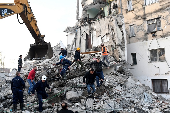 Des travailleurs d'urgence nettoient les débris d'un bâtiment endommagé à Thumane, à 34 kilomètres au nord-ouest de la capitale Tirana, après le séisme qui a frappé l'Albanie ce 26 novembre 2019. (Photo : GENT SHKULLAKU/AFP via Getty Images)