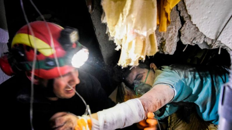 Un pompier tente de sauver un homme pris au piège dans les ruines d'un bâtiment effondré à Thumane, au nord-ouest de la capitale Tirana, après le tremblement de terre qui a eu lieu le 26 novembre 2019 en Albanie. (Armend Nimani / AFP via Getty Images)