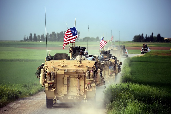 -Les forces américaines, accompagnées par des combattants des unités de protection du peuple kurde, conduisent leurs véhicules blindés dans le nord de la Syrie, à la frontière avec la Turquie. Photo DELIL SOULEIMAN / AFP via Getty Images.