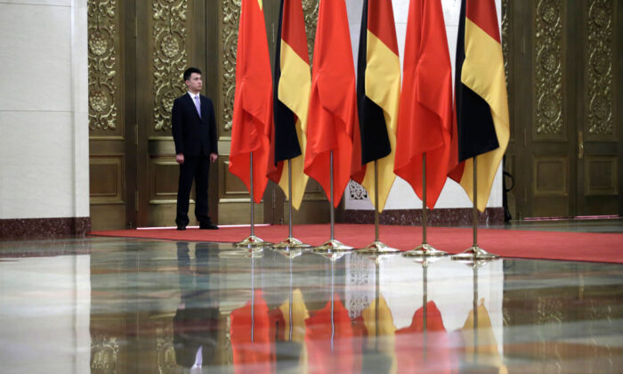 Un agent de sécurité monte la garde à côté des drapeaux chinois et allemands lors de la rencontre entre le dirigeant chinois Xi Jinping et la chancelière allemande Angela Merkel dans le Grand palais du Peuple à Pékin, le 24 mai 2018. (Jason Lee/AFP via Getty Images)