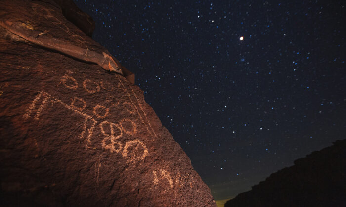 Une vue de la lune au-dessus d'un ancien pétroglyphe amérindien dans cette photo prise près de Barstow, Californie, le 20 janvier 2019. (David McNew/Getty Images)