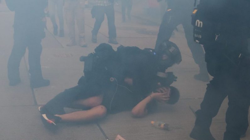 Un manifestant est arrêté par la police anti-émeute dans un nuage de gaz lacrymogène lors d'une manifestation dans le district de Tsim Sha Tsui le 20 octobre 2019 à Hong Kong. (Photo par Billy H.C. Kwok/Getty Images)