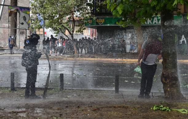 -La police anti-émeute tente de disperser des manifestants avec des canons à eau lors d'une manifestation contre la politique économique du gouvernement du président Sebastian Pinera, à Santiago, le 4 novembre 2019. Photo de RODRIGO ARANGUA / AFP via Getty Images.