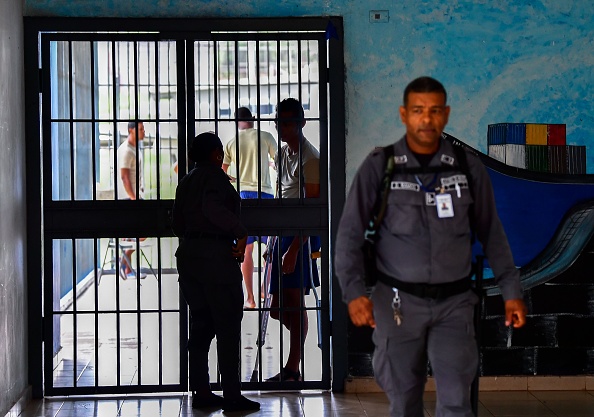 -Illustration- Un jeune détenu s'entretient avec un garde à travers une clôture, au centre de détention de Pacora, à la périphérie de Panama, le 22 novembre 2018. Photo LUIS ACOSTA / AFP via Getty Images.