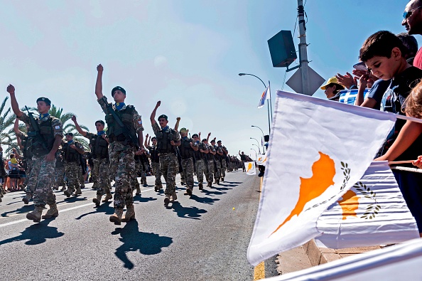 -Les Chypriotes agitent des drapeaux nationaux grec et chypriote lors d'un défilé militaire marquant le 59e anniversaire de l'indépendance de Chypre à la domination coloniale britannique, dans la capitale Nicosie, le 1er octobre 2019. Photo de Iakovos Hatzistavrou / AFP via Getty Images.