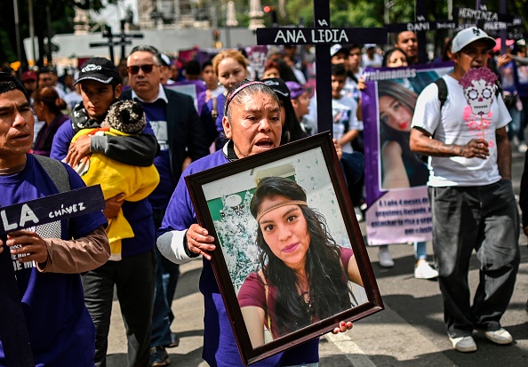 -Une femme tient une photo d'un parent assassiné lors d'une manifestation contre les féminicides, à Mexico, le 3 novembre 2019. Photo de PEDRO PARDO / AFP via Getty Images.