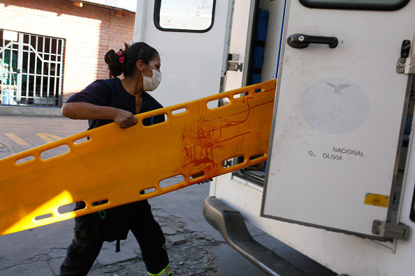 -Illustration- Un travailleur de la santé transporte une civière avec du sang dans une ambulance. Photo de Gaston Brito Miserocchi / Getty Images.