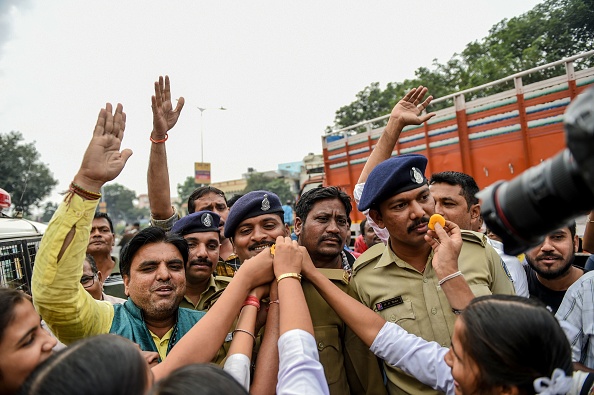 -Des écoliers offrent des gâteries aux policiers du Gujarat, les gens célèbrent la police d'Hyderabad après qu’elle ait abattu quatre personnes soupçonnées de viol et de meurtre en groupe à Shadnagar le 6 décembre 2019. Photo SAM PANTHAKY / AFP via Getty Images.