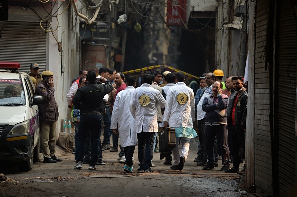 Une équipe de médecine légale marche le long d'une rue menant à un site d'usine où un incendie s'est déclaré, dans le quartier Anaj Mandi de New Delhi le 8 décembre 2019. (Photo : SAJJAD  HUSSAIN/AFP via Getty Images)