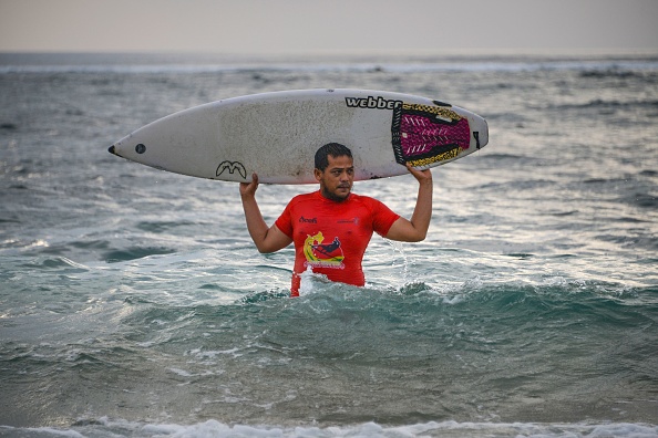 -Photo prise le 9 décembre 2019 montre Dery Setyawan, un survivant du tsunami du 26 décembre 2004, tenant sa planche de surf. Photo de CHAIDEER MAHYUDDIN / AFP via Getty Images