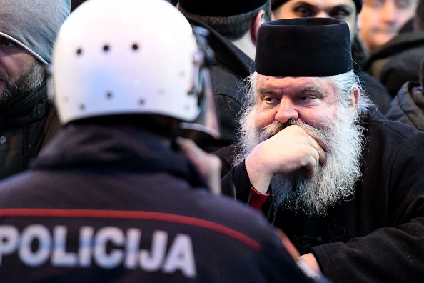 Le clergé et les croyants de l'Église orthodoxe serbe se tiennent devant la police près du Parlement, avant le vote d'une loi controversée sur la liberté religieuse à Podgorica le 26 décembre 2019. (Photo : SAVO PRELEVIC/AFP via Getty Images)