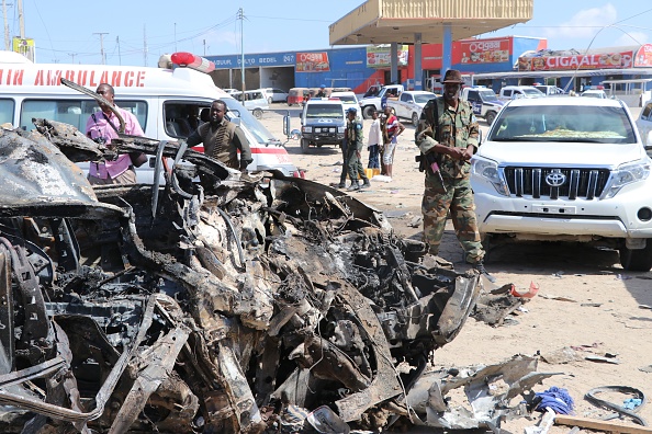 -Un soldat est vu à côté de l'épave d'une voiture qui a été endommagée lors de l'explosion d'une voiture piégée qui a explosé à Mogadiscio et qui a tué plus de 90 personnes. Il a été photographié à Mogadiscio le 28 décembre 2019. Photo par ABDIRAZAK HUSSEIN FARAH / AFP via Getty Images.