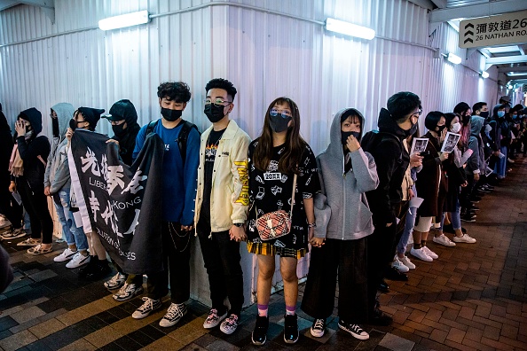 -Des manifestants participent à un rassemblement de chaînes humaines dans le quartier Tsim Sha Tsui de Hong Kong le 31 décembre 2019. Des manifestants pro-démocrate à Hong Kong se sont tenus par la main et ont formé des chaînes humaines à travers la ville mardi. Photo par ISAAC LAWRENCE / AFP via Getty Images.