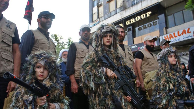 Des enfants en tenue militaire portent des armes lors d'une congrégation de l'organisation terroriste Hezbollah le 4 octobre 2017. (MAHMOUD ZAYYYAT/AFP/Getty Images)