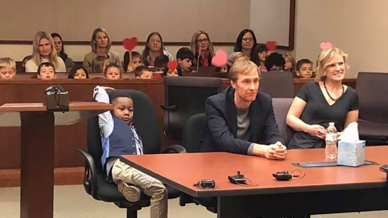 Toute la classe de maternelle de Michael, âgé de 5 ans, est assise dans le public derrière lui, agitant de grands cœurs rouges montés sur des bâtons de bois pour montrer leur soutien. (Comté de Kent, Michigan)