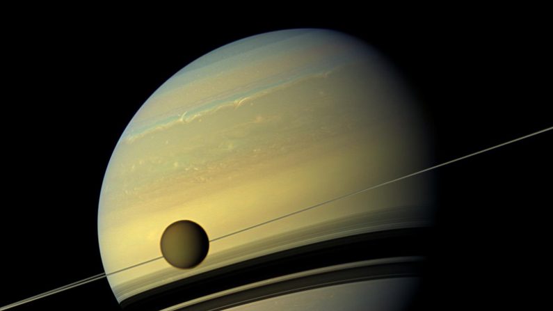 Une lune géante Titan apparaît devant la planète géante Saturne qui subit des changements saisonniers dans cette vue en couleur naturelle du vaisseau spatial Cassini de la NASA. (NASA/JPL-Caltech/Institut des sciences spatiales)