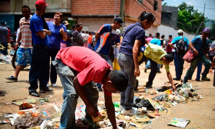 Des gens cherchent de la nourriture devant un supermarché pillé dans le quartier El Valle, à Caracas, au Venezuela, le 21 avril 2017. (Ronaldo Schemidt/AFP/Getty Images)