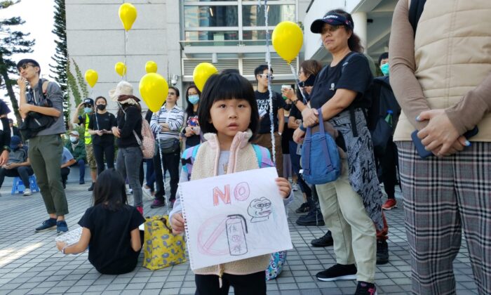 Une petite fille tient un croquis "Non au gaz lacrymogène" lors d'un rassemblement à Edinburgh Place à Hong Kong, le 1er décembre 2019. (Bill Cox/The Epoch Times)