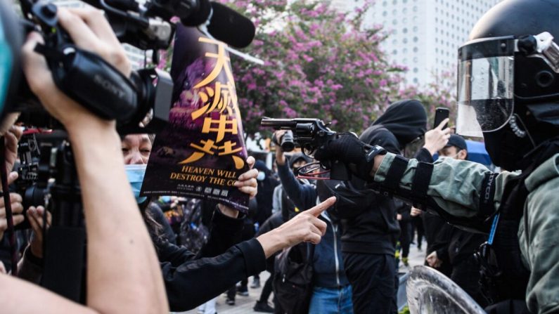 Un policier sort une arme à feu lors d'un rassemblement à Hong Kong le 22 décembre 2019. (Anthony Wallace/AFP/Getty Images)
