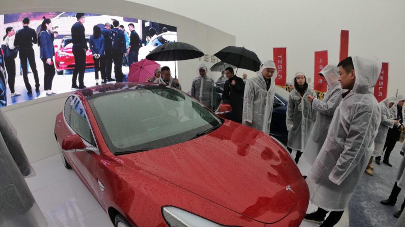 Des invités regardent une Tesla Model 3 lors d'une cérémonie d'inauguration des travaux d'une usine Tesla à Shanghai, en Chine, le 7 janvier 2019. (STR/AFP via Getty Images)