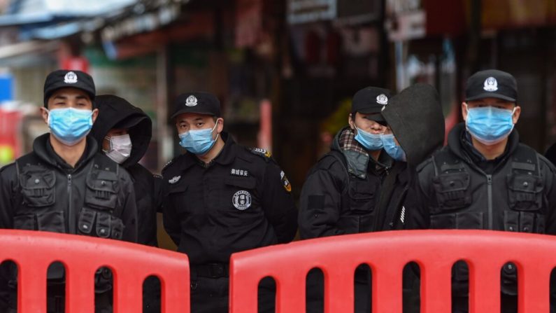 Des policiers et des agents de sécurité se tiennent devant le grand marché de fruits de mer de Huanan où le coronavirus a été détecté à Wuhan le 24 janvier 2020. (Hector Retamal/AFP via Getty Images)