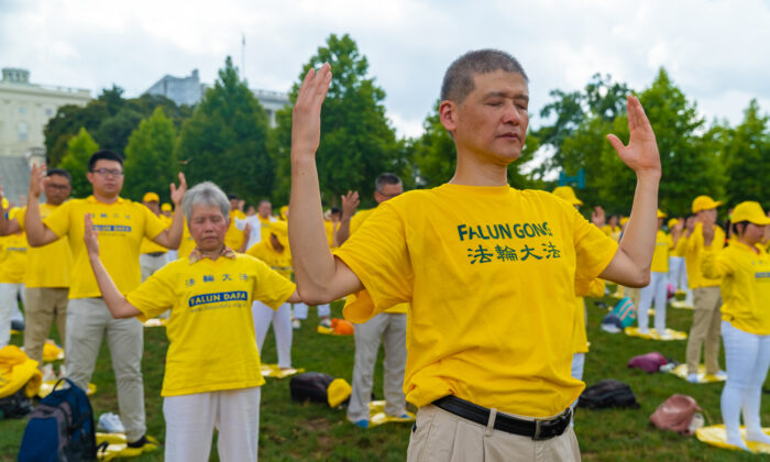 Les pratiquants de Falun Gong font les exercices lors d'un rassemblement commémorant le 20e anniversaire de la persécution du Falun Gong en Chine, sur la pelouse ouest de Capitol Hill le 18 juillet 2019. (Mark Zou / The Epoch Times)