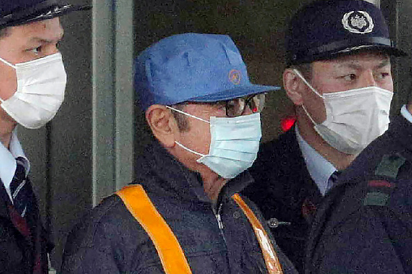 L'ancien président de Nissan, Carlos Ghosn est escorté lors de sa sortie du centre de détention de Tokyo après sa libération sous caution à Tokyo le 6 mars 2019. Photo par JIJI PRESS / AFP / Getty Images.