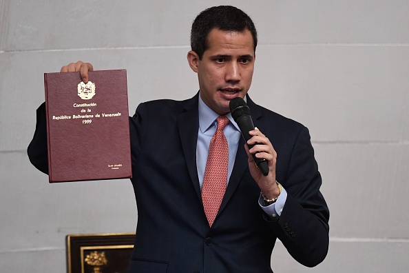 Le chef de l'opposition vénézuélienne et président par intérim  Juan Guaido montre une copie de la Constitution vénézuélienne de 1999 alors qu'il s'exprime lors d'une session extraordinaire de l'Assemblée nationale, à Caracas, le 17 décembre 2019. (Photo : FEDERICO PARRA/AFP via Getty Images)