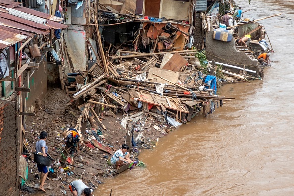 Les Indonésiens nettoient leurs maisons le long de la rivière à Jakarta le 3 janvier 2020, suite aux  inondations provoquées par de fortes pluies qui ont frappé la région le soir de Nouvel An.(Photo : BAY ISMOYO/AFP via Getty Images)