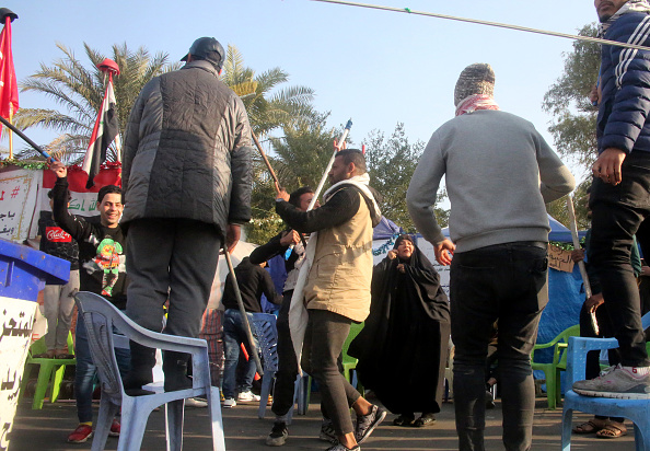Des manifestants anti-gouvernementaux irakiens célèbrent devant leurs tentes de protestation sur la place Tahrir de Bagdad à la suite de l'annonce de la mort du commandant en chef des Gardiens de la révolution, Qasem Soleimani, lors d'un raid américain contre son convoi à l'aéroport international de Bagdad le 3 janvier 2020. (Photo :AFP via Getty Images)
