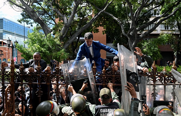 -Le chef de l'opposition vénézuélienne et président par intérim autoproclamé Juan Guaido est aidé à monter sur une rambarde pour tenter d'atteindre le bâtiment de l'Assemblée nationale à Caracas, le 5 janvier 2020. Photo de FEDERICO PARRA / AFP via Getty Images.
