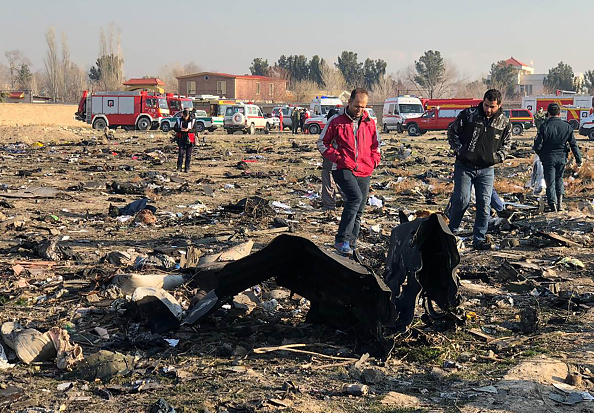 -Les gens marchent près de l'épave après qu'un avion ukrainien transportant 176 passagers s'est écrasé près de l'aéroport Imam Khomeini de Téhéran tôt le matin du 8 janvier 2020, tuant tout le monde à bord. Photo par - / AFP via Getty Images.