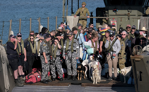 Des péniches de débarquement militaires arrivent avec des pompiers bénévoles et des évacués le 8 janvier 2020 à Hastings, en Australie. Les 205 personnes retournent à Melbourne après avoir été évacuées de la ville côtière victorienne de Mallacoota, qui a été coupée du monde depuis que des feux de brousse ont ravagé la région la veille du Nouvel An. (Photo : Luis Ascui/Getty Images)