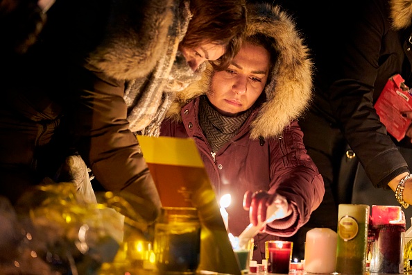 -Des personnes en deuil allument des bougies pour les victimes du vol 752 d'Ukrainian Airlines qui s'est écrasé en Iran, lors d'une veillée à Toronto, en Ontario, le 9 janvier 2020. Photo de GEOFF ROBINS / AFP via Getty Images.
